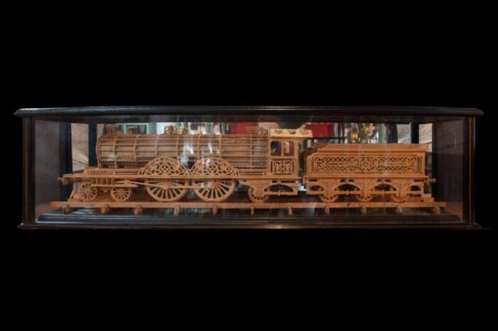 carved wood model of a locomotive in black lacquered and glass case 1667