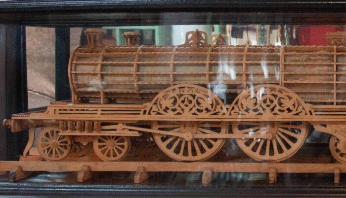 carved wood model of a locomotive in black lacquered and glass case 7423